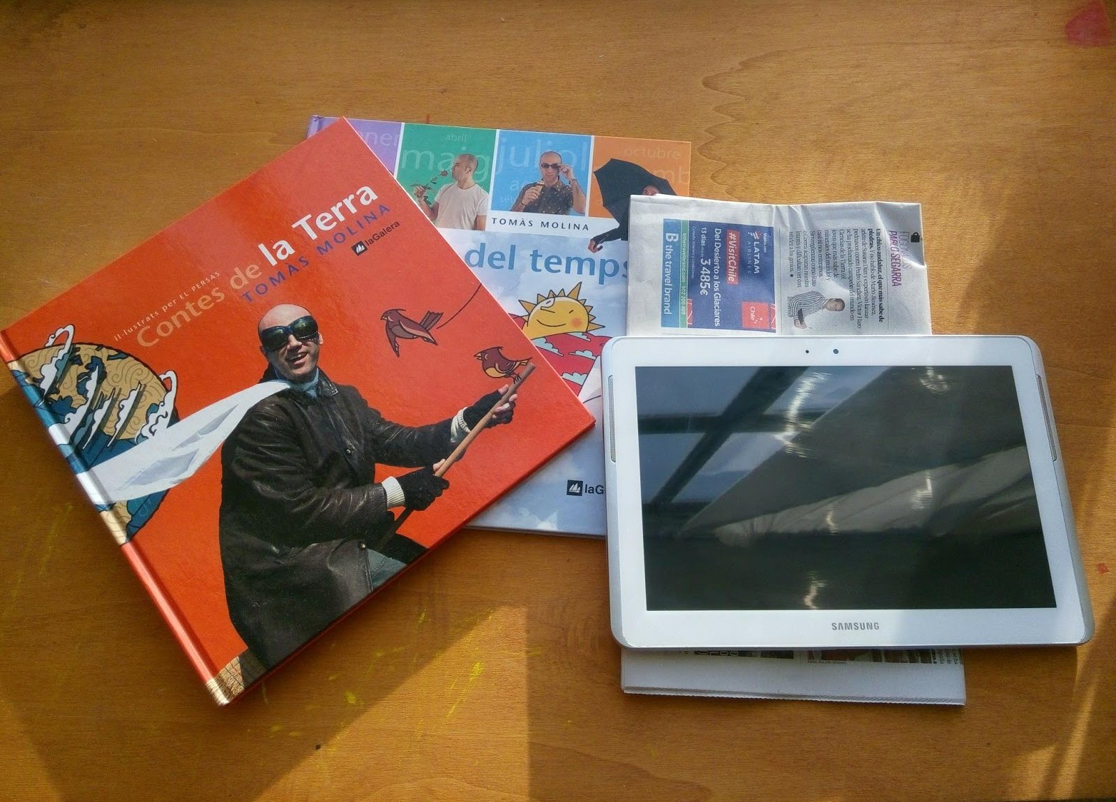 Fotografía de 2 libros, un periódico y una tablet para el taller de memoria-lectura.