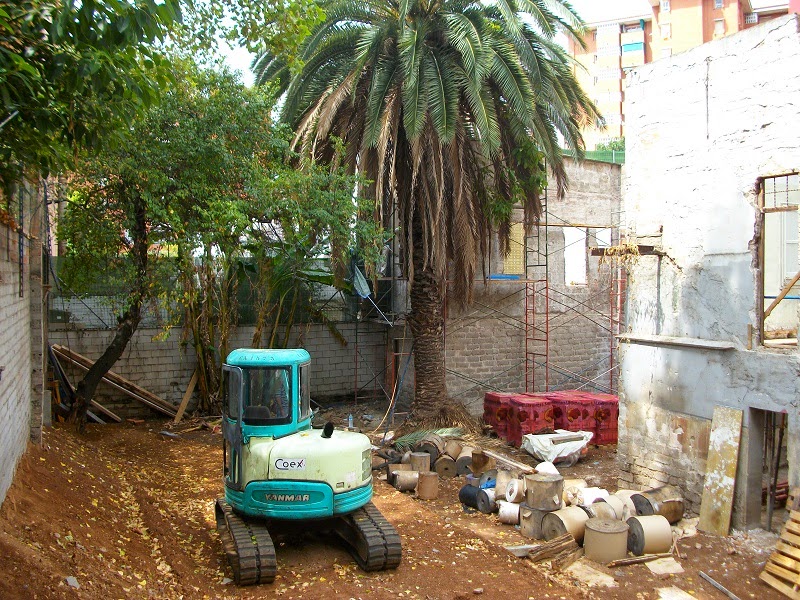 Fotografía exterior del edificio del hogar-residencia en plena reconstrucción con máquina para allanar el terreno