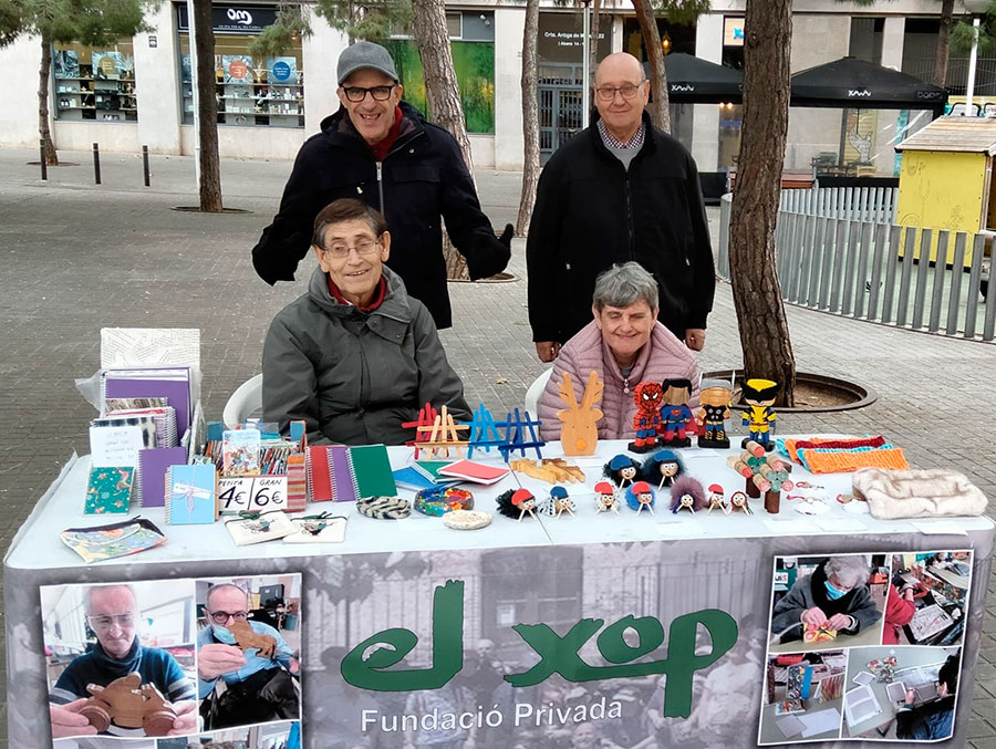 4 usuaris en una parada de venda de productes realitzats en el Centre Ocupacional d'El Xop.